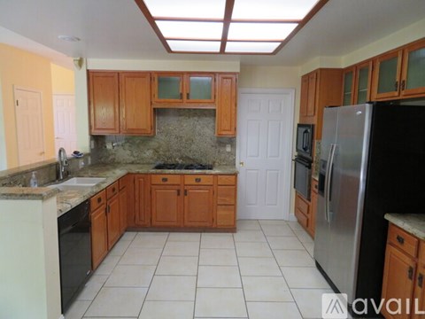 A kitchen with wooden cabinets and a granite countertop.