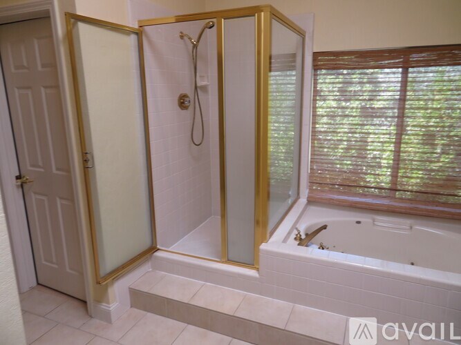 A bathroom with a gold-framed shower and tub.