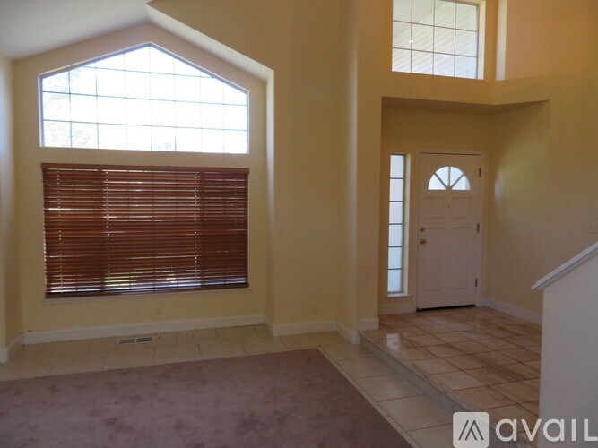 A room with a large window and a door is available for rent.