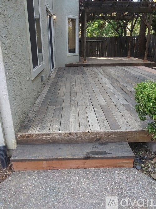 A wooden deck with a white door and windows.