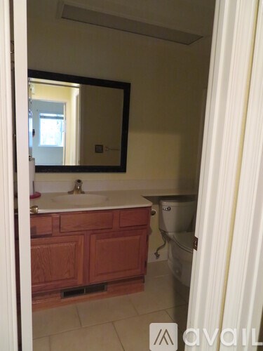 A bathroom with a sink, mirror and toilet.