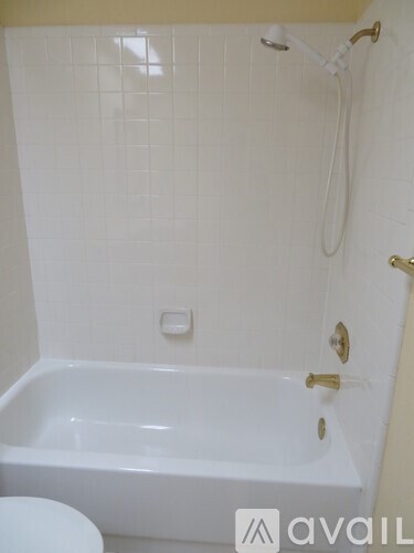 A white bathroom with a tub and toilet.