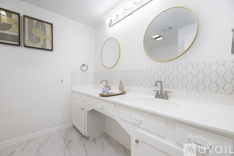 A white bathroom with a double sink and a mirror above it.
