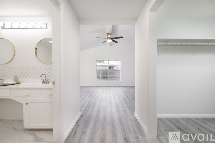 A spacious bathroom with a white vanity and a large mirror.