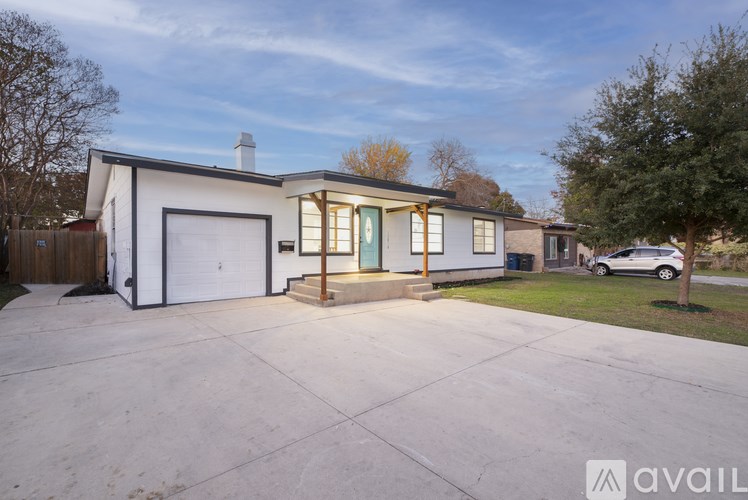A modern house with a white garage door and a brown wooden fence.