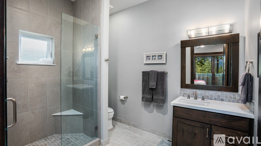 A bathroom with a glass shower door and a white sink.