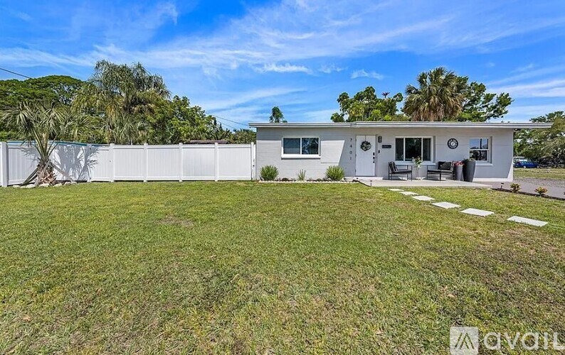 A house with a white exterior and a large lawn in front.
