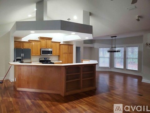 A kitchen with wooden cabinets and a large island.