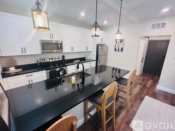 A kitchen with black countertops and white cabinets.