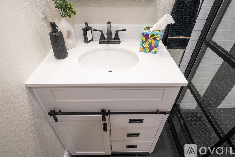 A modern kitchen with black countertops and white cabinets.