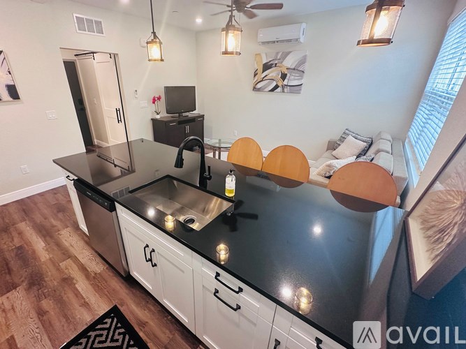 A kitchen with a black countertop and white cabinets.