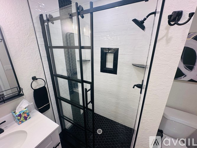 A white sink with a glass shower door in a bathroom.
