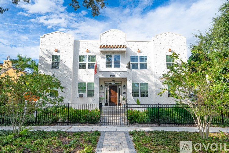 A white toilet in a small bathroom with a black metal staircase.