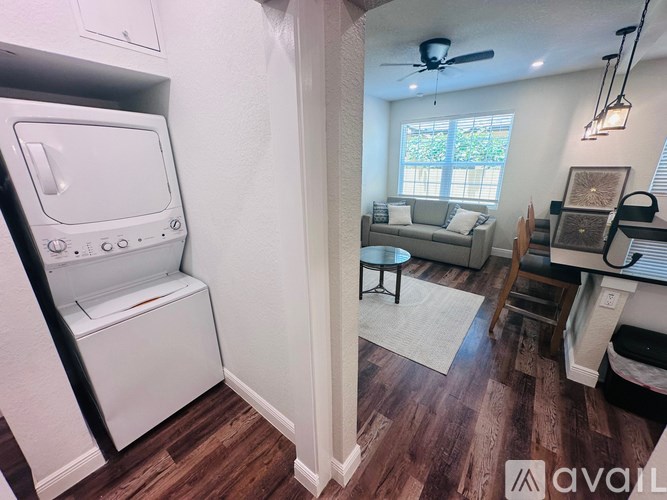 A kitchen with a washing machine and a living room with a couch.
