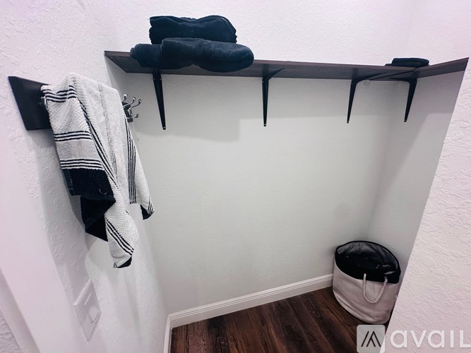 A bathroom with a towel rack and a trash can.