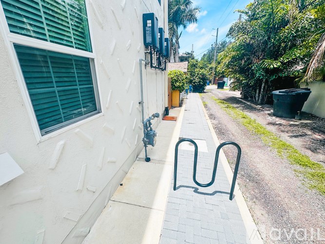 A bike rack is on the sidewalk next to a building.