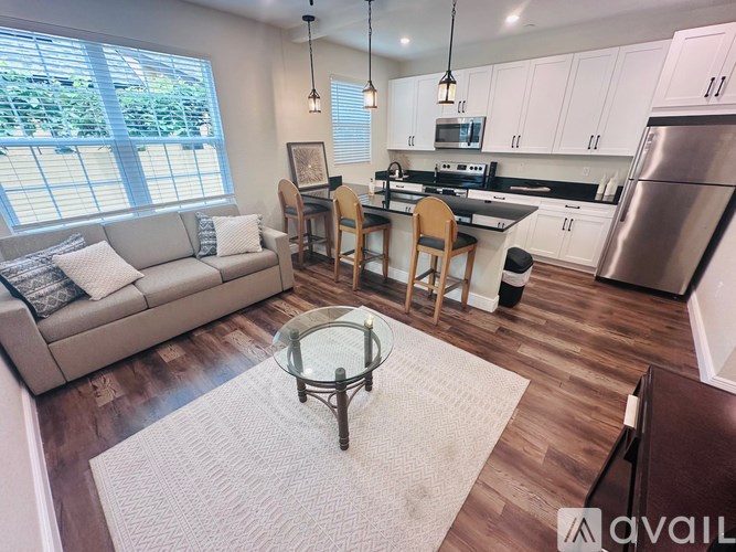 A modern kitchen with a dining table and chairs is available for rent.