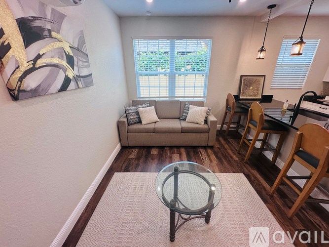 A living room with a couch, chairs, and a coffee table.