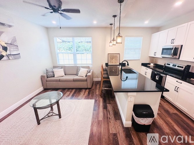 A kitchen with a black counter top and white cabinets.