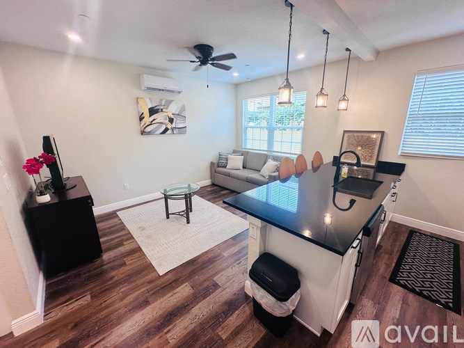 A kitchen with a black countertop and a fan on the ceiling.