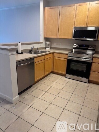 A kitchen with wooden cabinets and a white dishwasher.