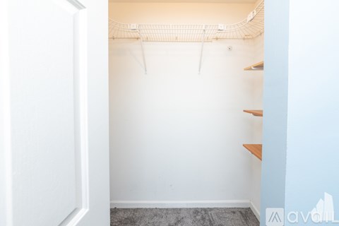 A white door is open to a room with a white wall and a white ceiling.