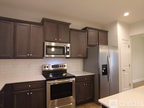 A kitchen with dark brown cabinets and stainless steel appliances.