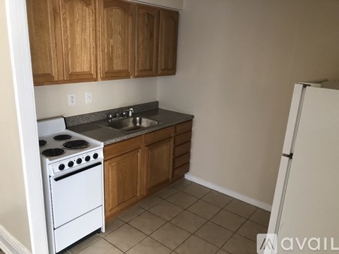 A kitchen with wooden cabinets and a white stove.