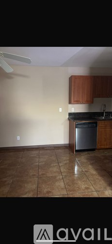 A kitchen with brown cabinets and a stainless steel dishwasher.