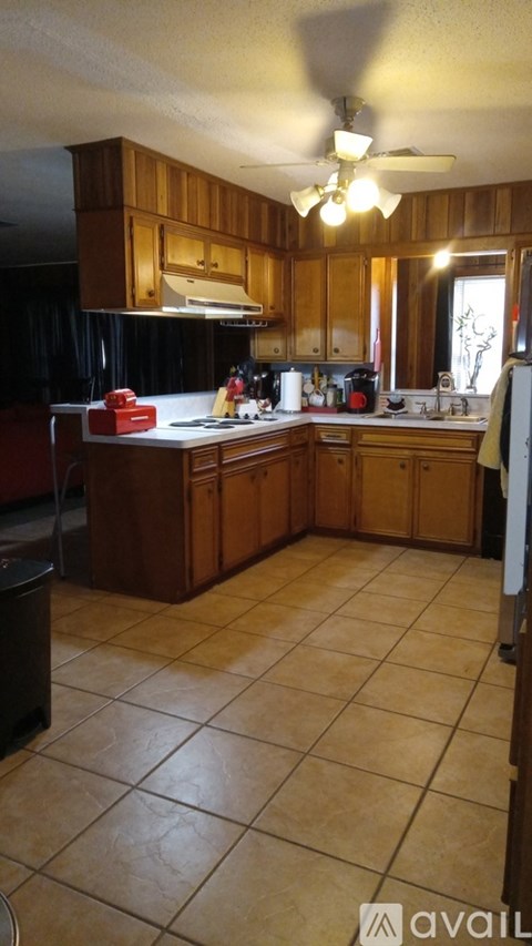 A kitchen with wooden cabinets and a tiled floor.