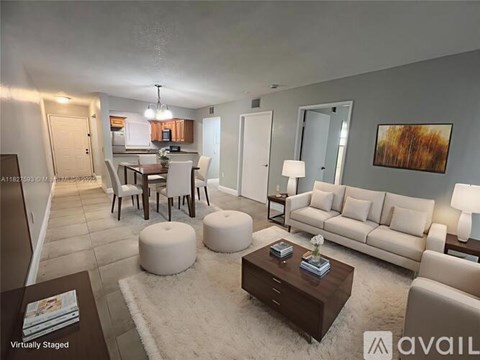 A living room with a white couch, a coffee table, and a dining table with chairs.