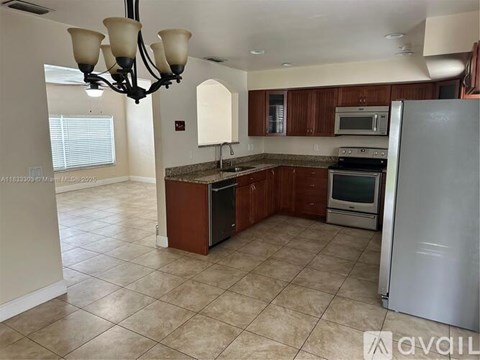 A kitchen with a refrigerator, oven, and microwave.