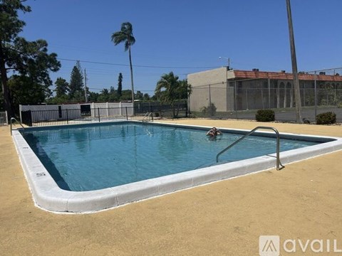 A small pool with a metal ladder and a fence around it.