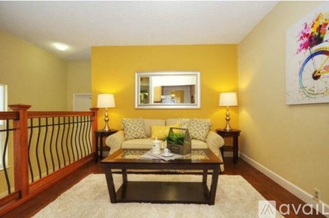 A living room with a sofa, two lamps, and a painting on the wall.