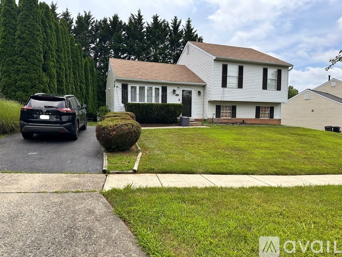 A house with a driveway and a lawn in front.