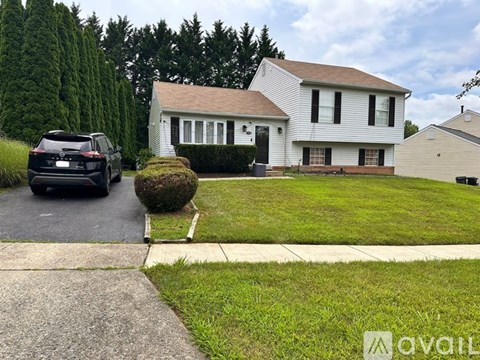 A house with a driveway and a lawn in front.