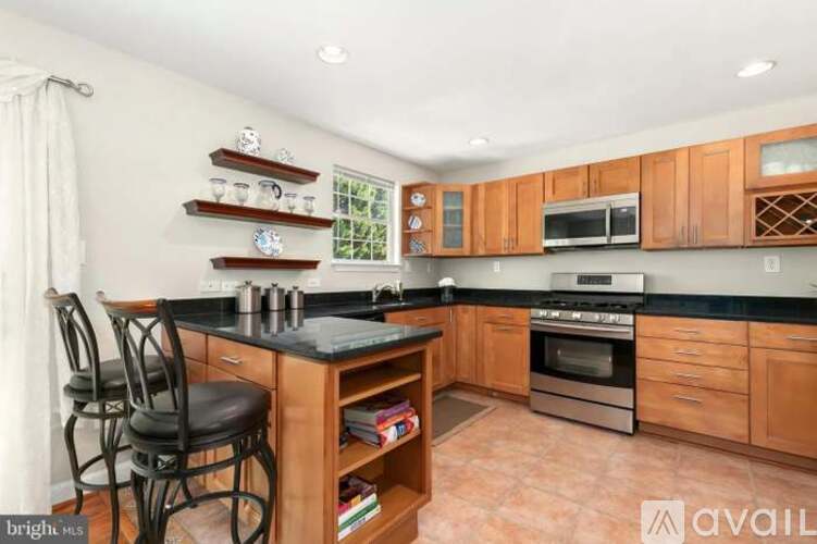 A kitchen with wooden cabinets and black countertops.