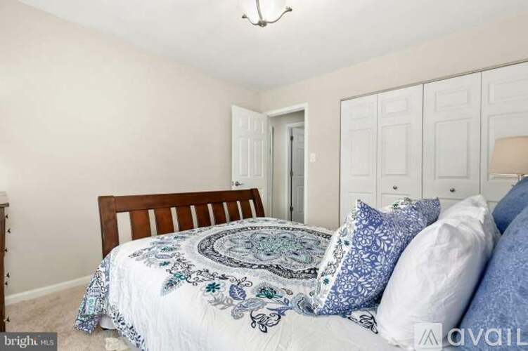 A bedroom with a bed, pillows, and a chandelier.