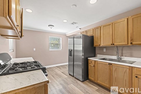 A kitchen with wooden cabinets and a marble countertop.