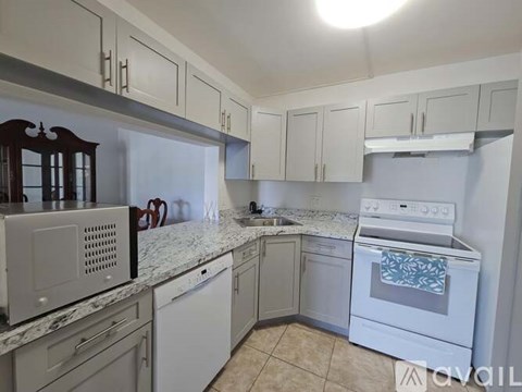 A kitchen with white cabinets and a white oven.