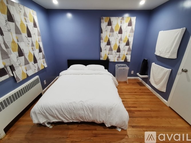 A bedroom with a white bed and a blue wall.