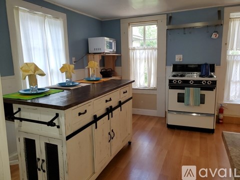 A kitchen with wooden cabinets and a stove top oven.