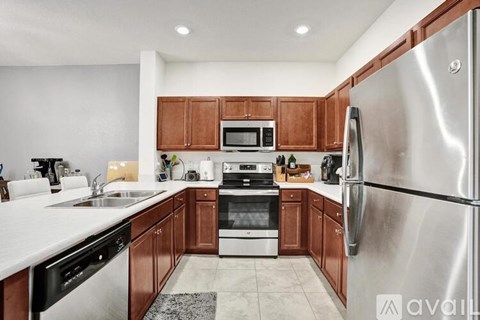 A kitchen with brown cabinets and a stainless steel refrigerator.