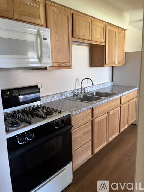 A kitchen with wooden cabinets and a white stove top oven.