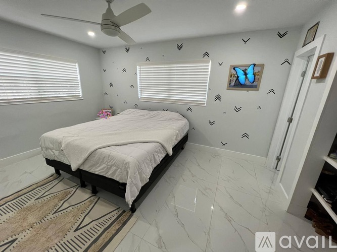 A bedroom with a bed, a ceiling fan, and a rug.