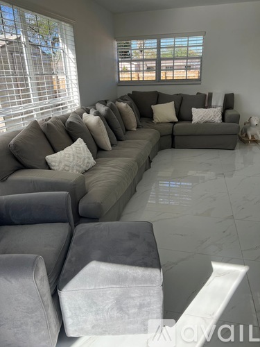 A living room with a grey couch and pillows.