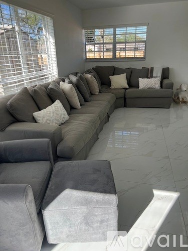 A living room with a grey couch and pillows.