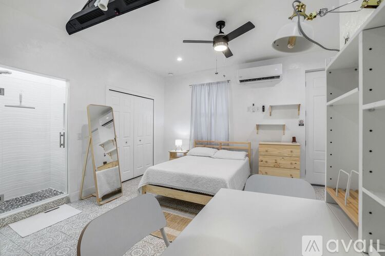 A spacious room with a ceiling fan and a door leading to another room.