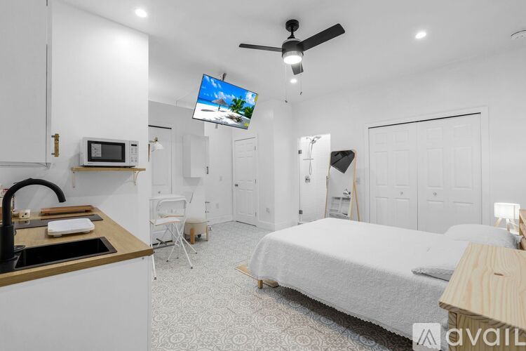 A white bathroom with a glass shower stall and a white door.