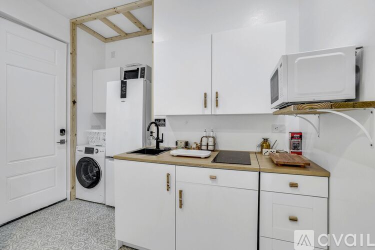 A white bathroom with a toilet, sink, and a window.